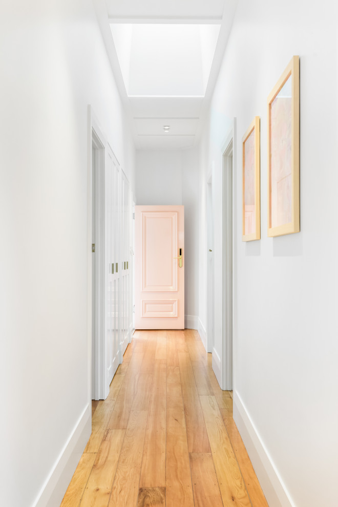 Cette photo montre un couloir chic de taille moyenne avec un mur blanc, un sol en bois brun, un sol marron et un plafond à caissons.