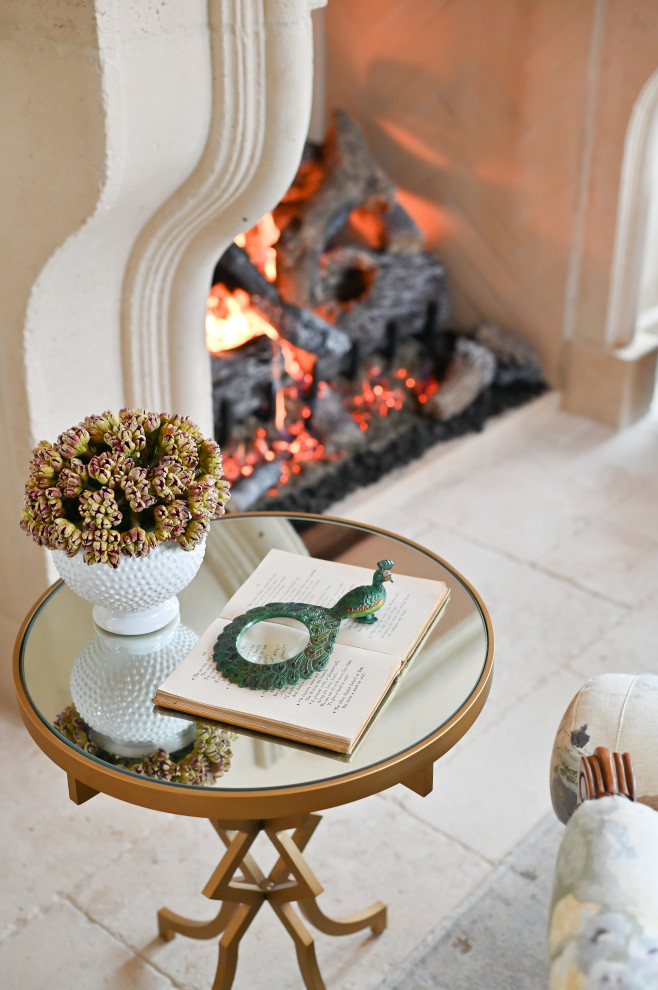 Cette image montre une petite véranda avec un sol en calcaire, une cheminée standard, un manteau de cheminée en pierre, un plafond standard et un sol beige.