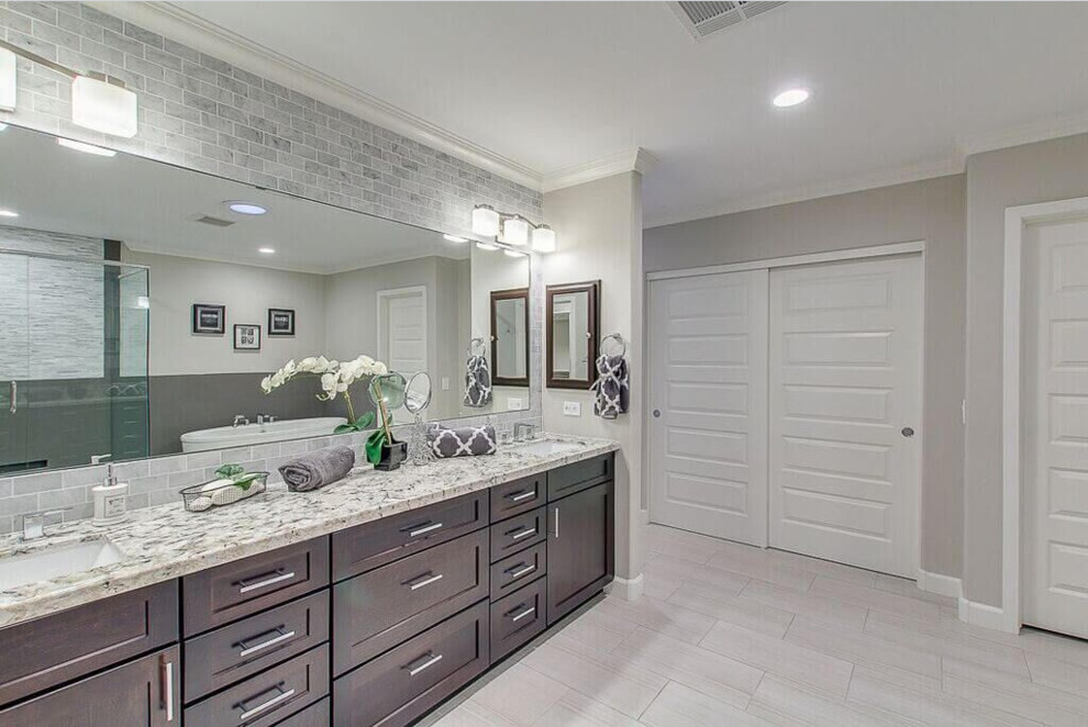 Freestanding bathtub - large transitional master gray tile and subway tile porcelain tile and beige floor freestanding bathtub idea in Phoenix with dark wood cabinets, gray walls, granite countertops, shaker cabinets, an undermount sink and a hinged shower door