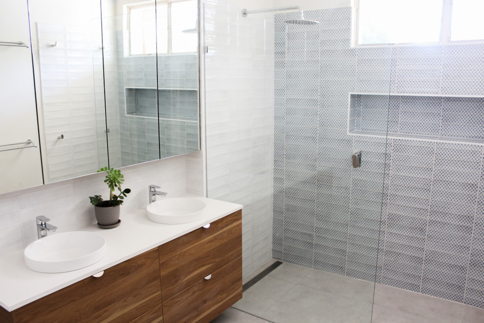 Inspiration for a large modern kids bathroom in Perth with flat-panel cabinets, dark wood cabinets, an open shower, a two-piece toilet, blue tile, subway tile, blue walls, porcelain floors, a vessel sink, engineered quartz benchtops, grey floor, an open shower and white benchtops.