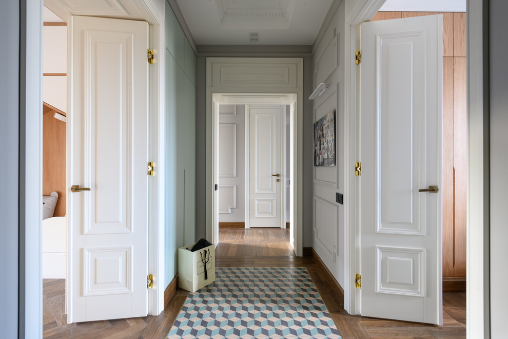 Photo of a mid-sized transitional hallway in Other with white walls, medium hardwood floors and brown floor.