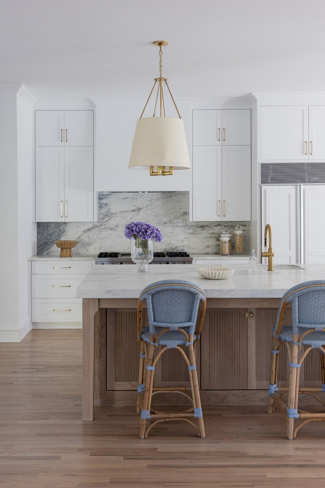 Example of a huge transitional single-wall light wood floor and brown floor eat-in kitchen design in Dallas with an undermount sink, shaker cabinets, white cabinets, quartzite countertops, white backsplash, stone slab backsplash, stainless steel appliances, an island and white countertops