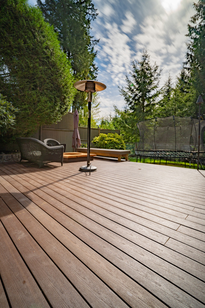 Design ideas for a large contemporary backyard and ground level deck in Vancouver with a fire feature.