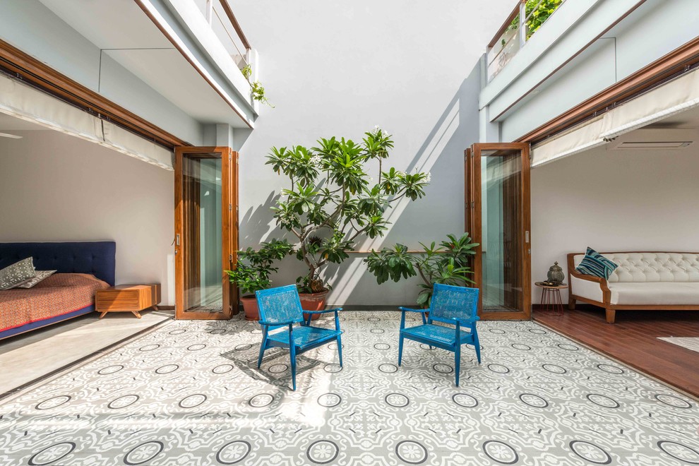 Large Asian Courtyard patio in Delhi With Grey Walls, Tile and No Cover.