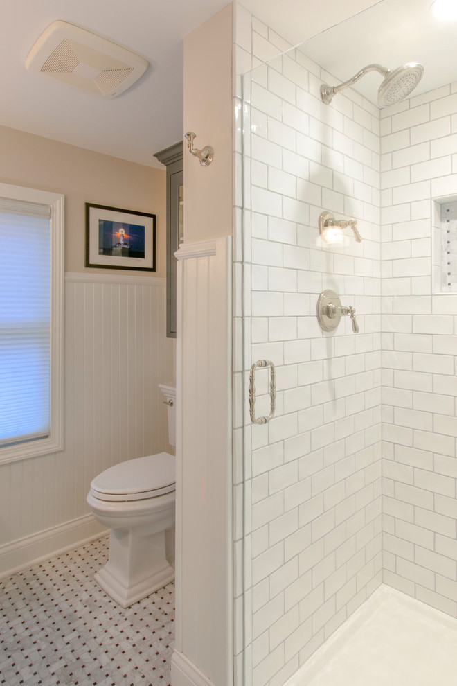 This is an example of a small transitional master bathroom in Milwaukee with beaded inset cabinets, grey cabinets, a corner shower, a two-piece toilet, white tile, subway tile, beige walls, marble floors, an undermount sink, quartzite benchtops, grey floor, a hinged shower door and white benchtops.