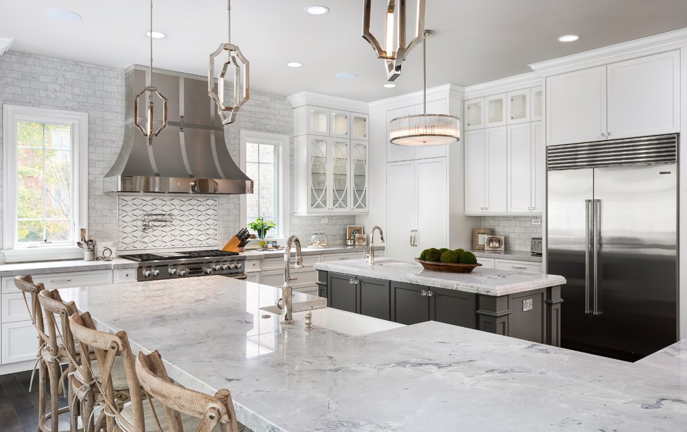 Huge transitional l-shaped dark wood floor and brown floor eat-in kitchen photo in Chicago with stainless steel appliances, a farmhouse sink, recessed-panel cabinets, white cabinets, granite countertops, white backsplash, subway tile backsplash and two islands