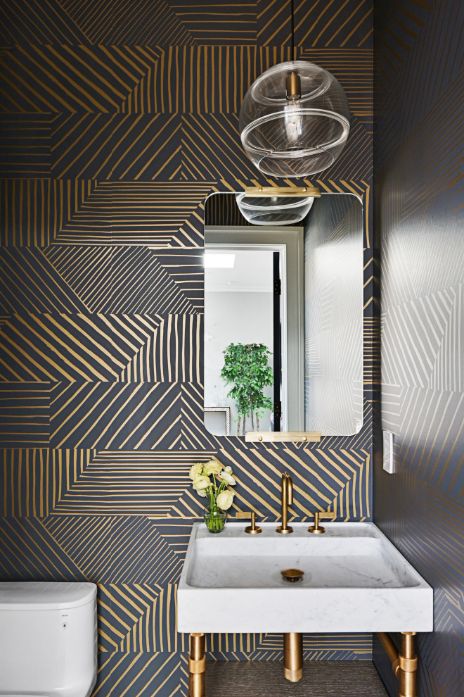 Trendy wallpaper powder room photo in San Francisco with white countertops, a freestanding vanity, multicolored walls and a console sink
