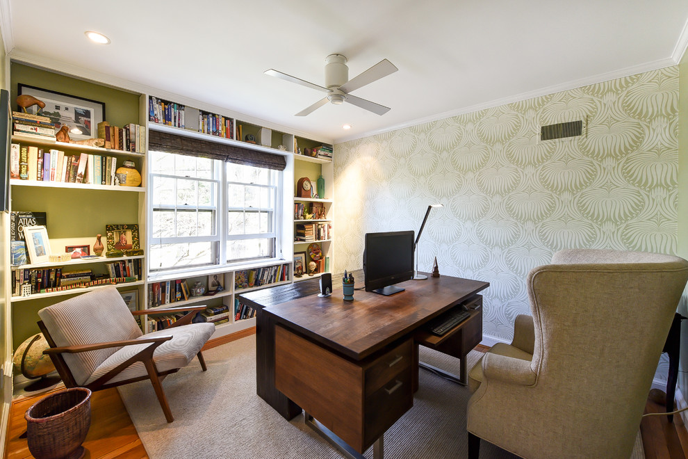 Design ideas for a mid-sized eclectic study room in DC Metro with green walls, light hardwood floors, a freestanding desk, brown floor and no fireplace.