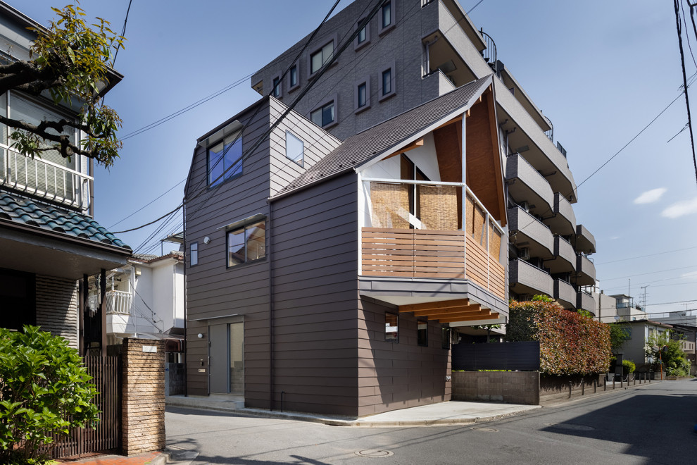 Mittelgroßes, Dreistöckiges Asiatisches Einfamilienhaus mit Metallfassade, brauner Fassadenfarbe, Satteldach, Blechdach und braunem Dach in Tokio