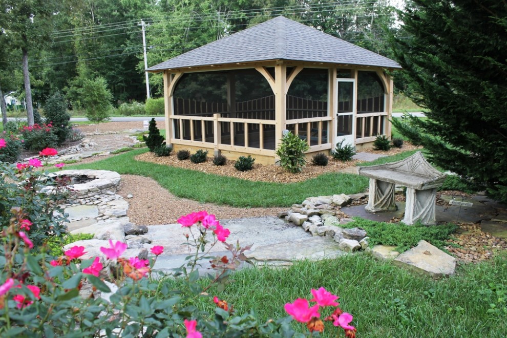 Photo of a mid-sized traditional backyard patio in Nashville with a fire feature, natural stone pavers and a pergola.