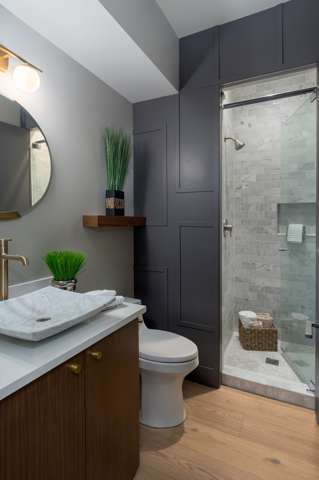 Contemporary 3/4 bathroom in Seattle with flat-panel cabinets, dark wood cabinets, a corner shower, gray tile, grey walls, light hardwood floors, a vessel sink and a hinged shower door.