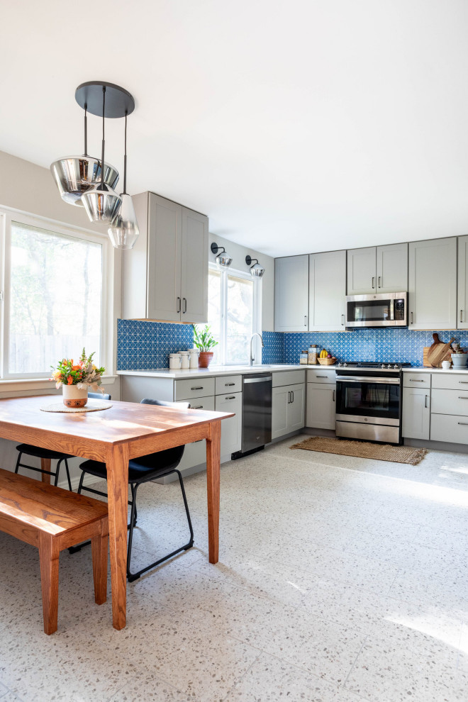 Mid-sized transitional l-shaped multicolored floor enclosed kitchen photo in Austin with an undermount sink, shaker cabinets, gray cabinets, quartz countertops, blue backsplash, ceramic backsplash, stainless steel appliances, no island and white countertops