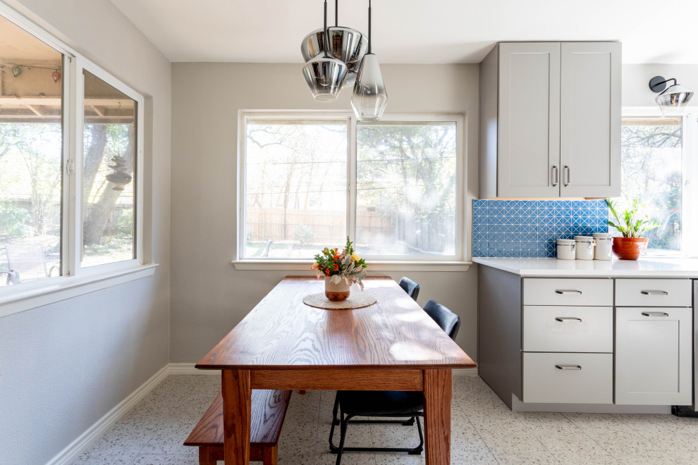 Mid-sized transitional u-shaped terrazzo floor and multicolored floor enclosed kitchen photo in Austin with a double-bowl sink, shaker cabinets, gray cabinets, quartz countertops, blue backsplash, ceramic backsplash, stainless steel appliances, no island and white countertops