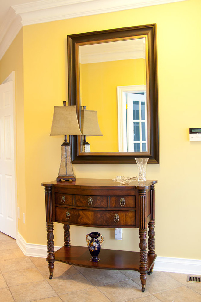 Photo of a mid-sized contemporary hallway in Toronto with yellow walls and medium hardwood floors.