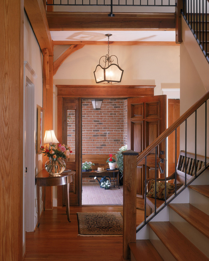 Design ideas for a mid-sized country foyer in Charlotte with white walls, medium hardwood floors, a single front door and a dark wood front door.