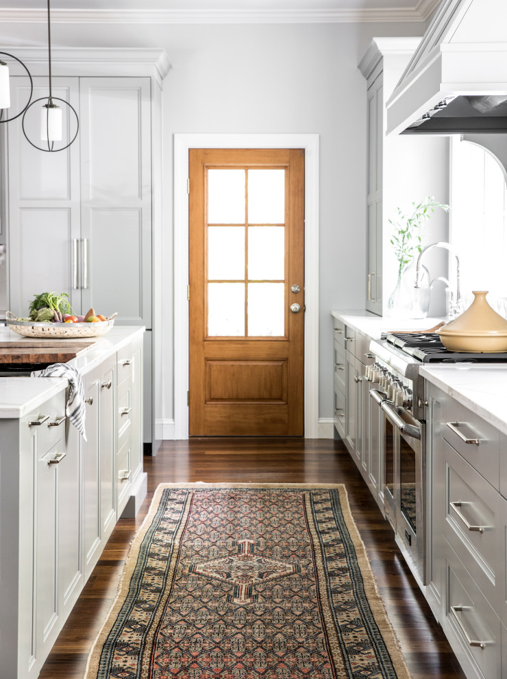 Large transitional eat-in kitchen in Portland Maine with an undermount sink, flat-panel cabinets, grey cabinets, quartz benchtops, multi-coloured splashback, stone tile splashback, panelled appliances, dark hardwood floors, with island, brown floor and white benchtop.