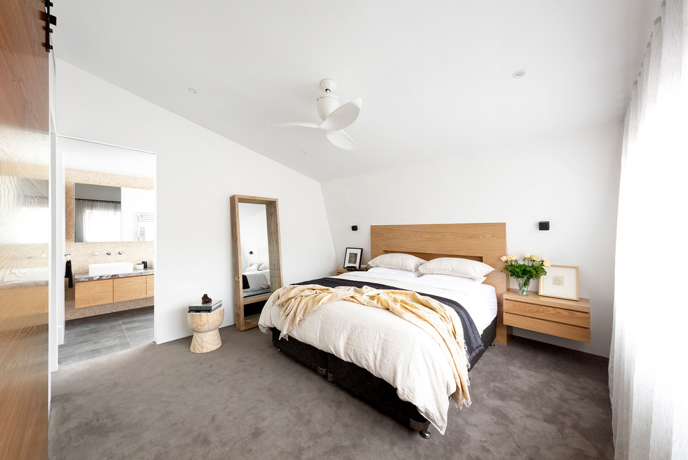 This is an example of a mid-sized contemporary master bedroom in Melbourne with white walls, carpet and grey floor.