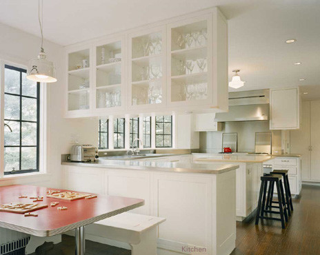 Photo of a mid-sized contemporary u-shaped eat-in kitchen in New York with an undermount sink, recessed-panel cabinets, white cabinets, marble benchtops, white splashback, stainless steel appliances, medium hardwood floors, with island and brown floor.