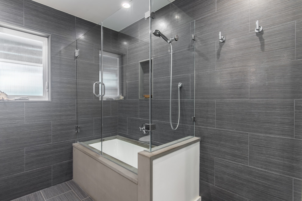 Inspiration for a small modern master bathroom in Dallas with flat-panel cabinets, white cabinets, an undermount tub, a shower/bathtub combo, a two-piece toilet, black tile, porcelain tile, white walls, porcelain floors, an undermount sink and granite benchtops.
