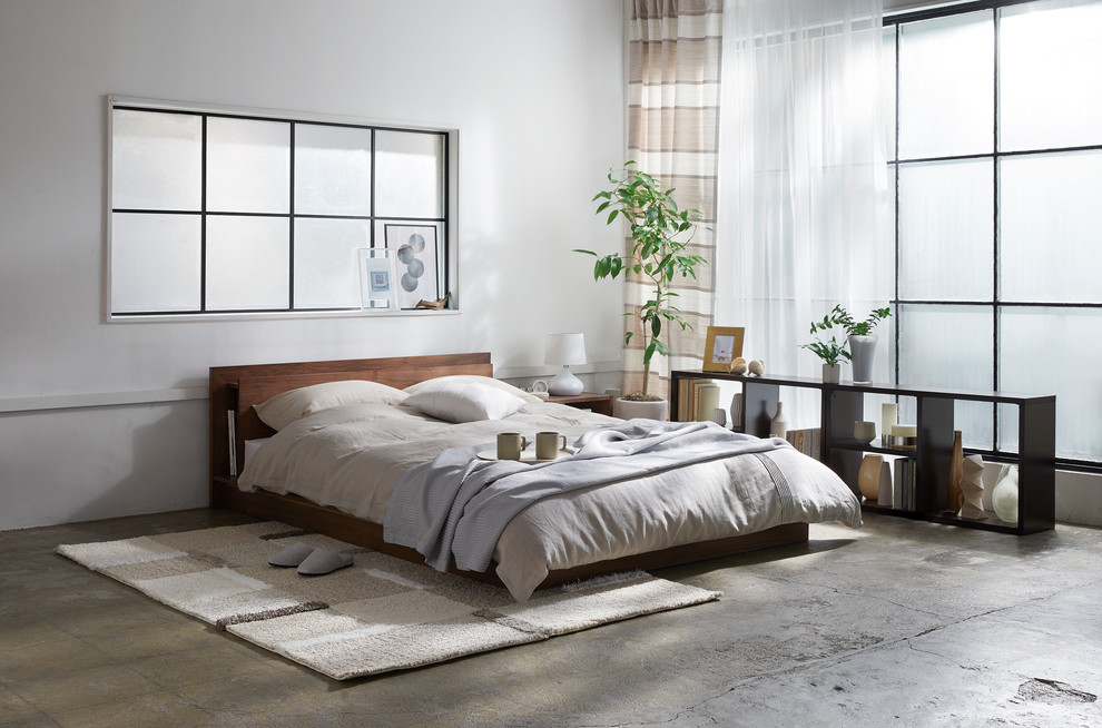 Bild på ett nordiskt sovrum, med vita väggar, betonggolv och grått golv