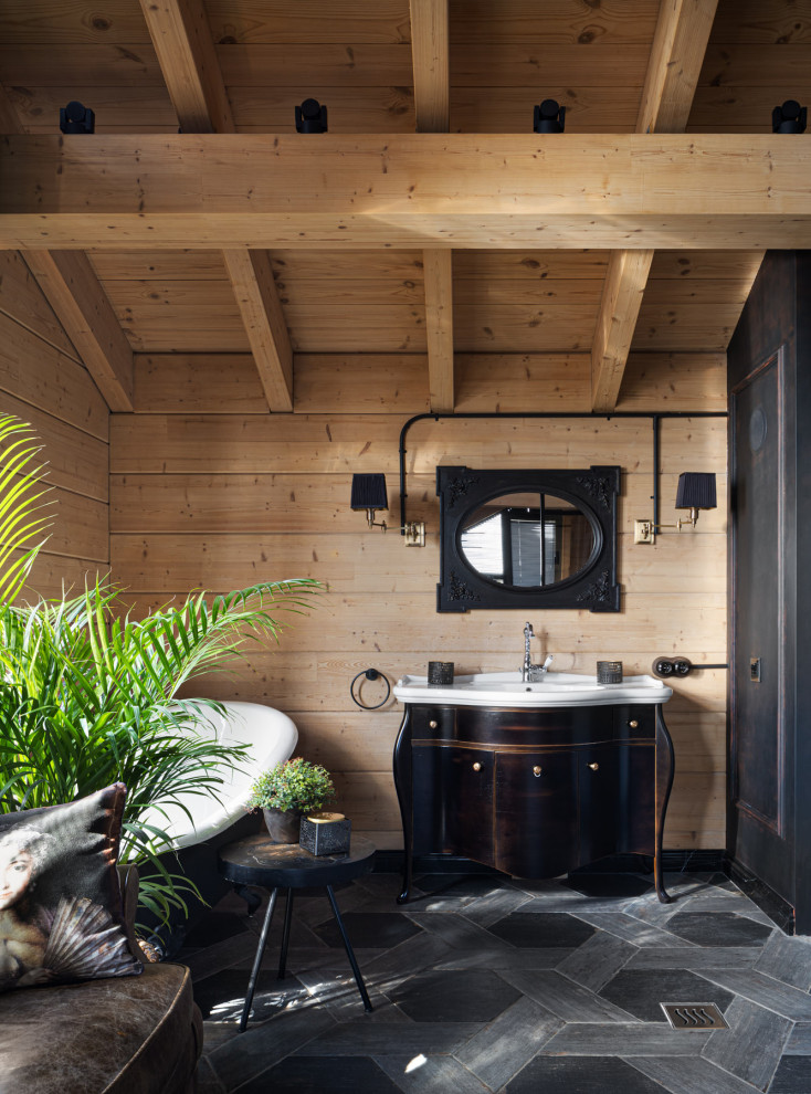 На фото: большая главная ванная комната в деревянном доме в стиле лофт с фасадами в стиле шейкер, черными фасадами, ванной на ножках, душем в нише, унитазом-моноблоком, серой плиткой, плиткой, черными стенами, полом из плитки под дерево, накладной раковиной, серым полом, душем с распашными дверями, белой столешницей, тумбой под одну раковину, напольной тумбой, балками на потолке и деревянными стенами с