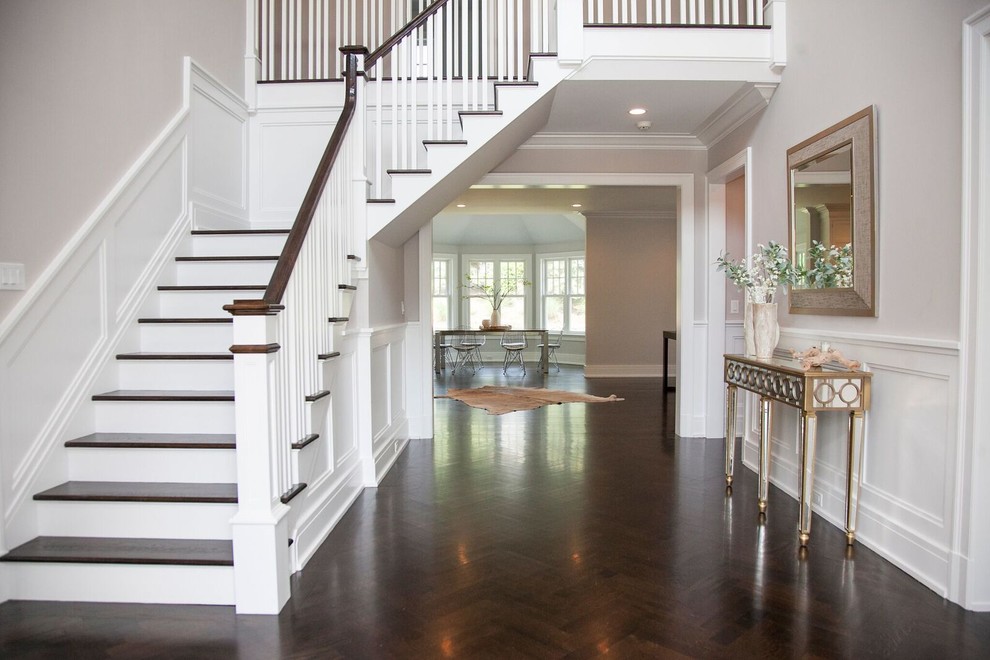 Design ideas for a large transitional foyer in New York with white walls and dark hardwood floors.