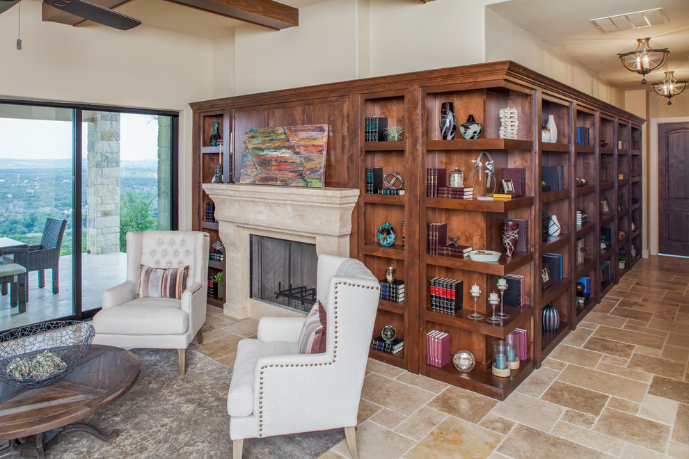 This is an example of an expansive traditional open concept family room in Austin with a library, beige walls, travertine floors, a standard fireplace and a stone fireplace surround.