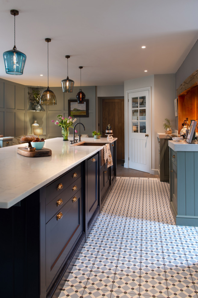 Design ideas for an expansive country galley eat-in kitchen in Cornwall with a drop-in sink, shaker cabinets, green cabinets, quartzite benchtops, orange splashback, coloured appliances, dark hardwood floors, with island, brown floor and white benchtop.