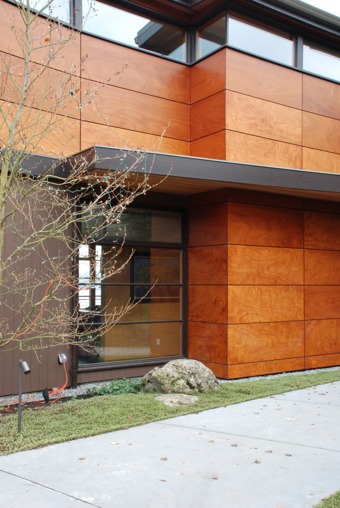 This is an example of a contemporary two-storey brown exterior in Seattle with wood siding and a shed roof.