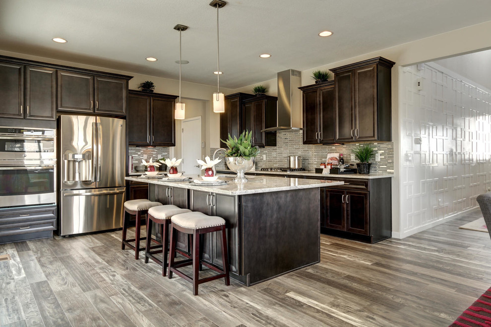 Mid-sized transitional l-shaped porcelain tile open concept kitchen photo in Denver with an island, an undermount sink, recessed-panel cabinets, dark wood cabinets, granite countertops, white backsplash, mosaic tile backsplash and stainless steel appliances