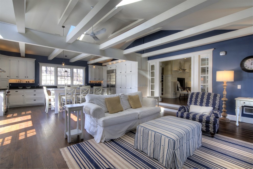 This is an example of a large beach style open concept living room in Providence with blue walls and laminate floors.