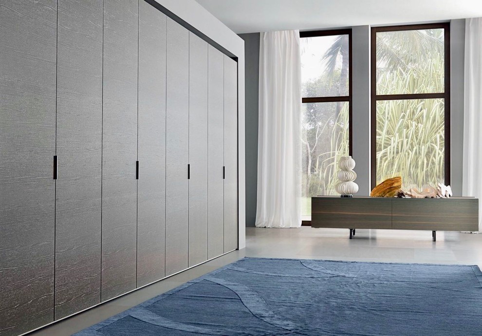 Photo of a large contemporary gender-neutral built-in wardrobe in Miami with flat-panel cabinets, dark wood cabinets and grey floor.