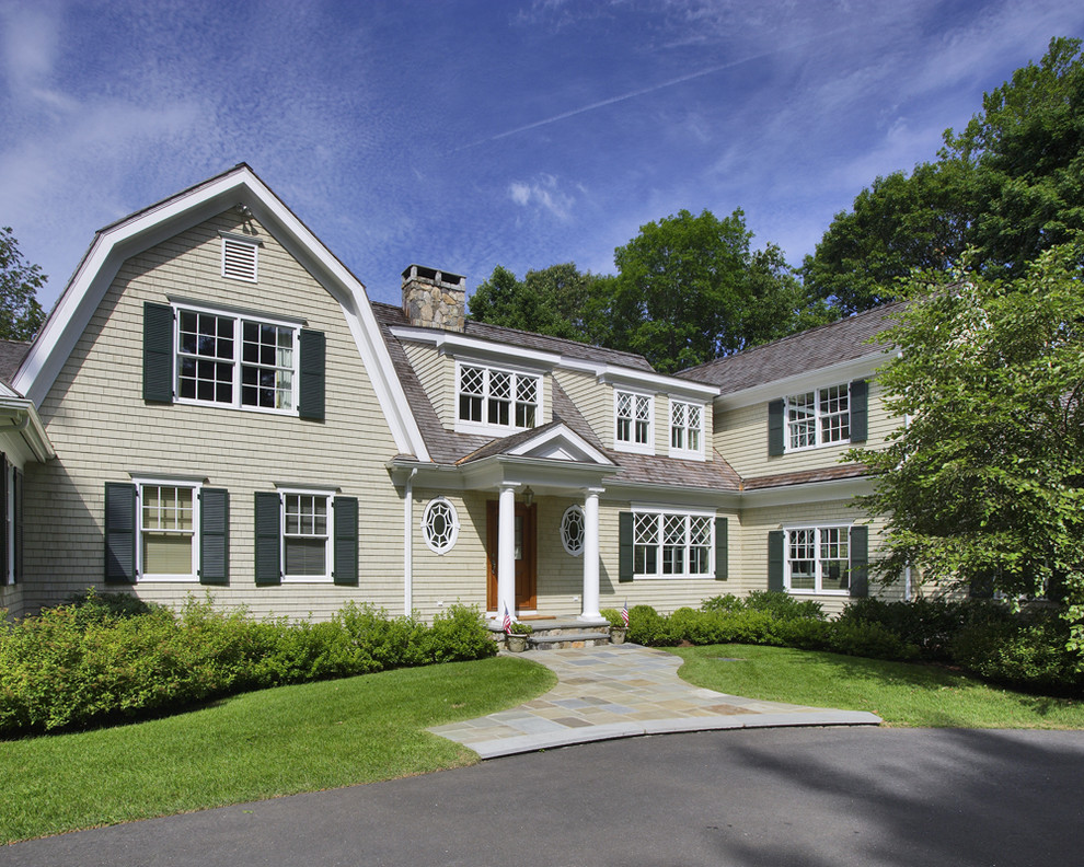 Traditional two-storey grey exterior in New York with wood siding.