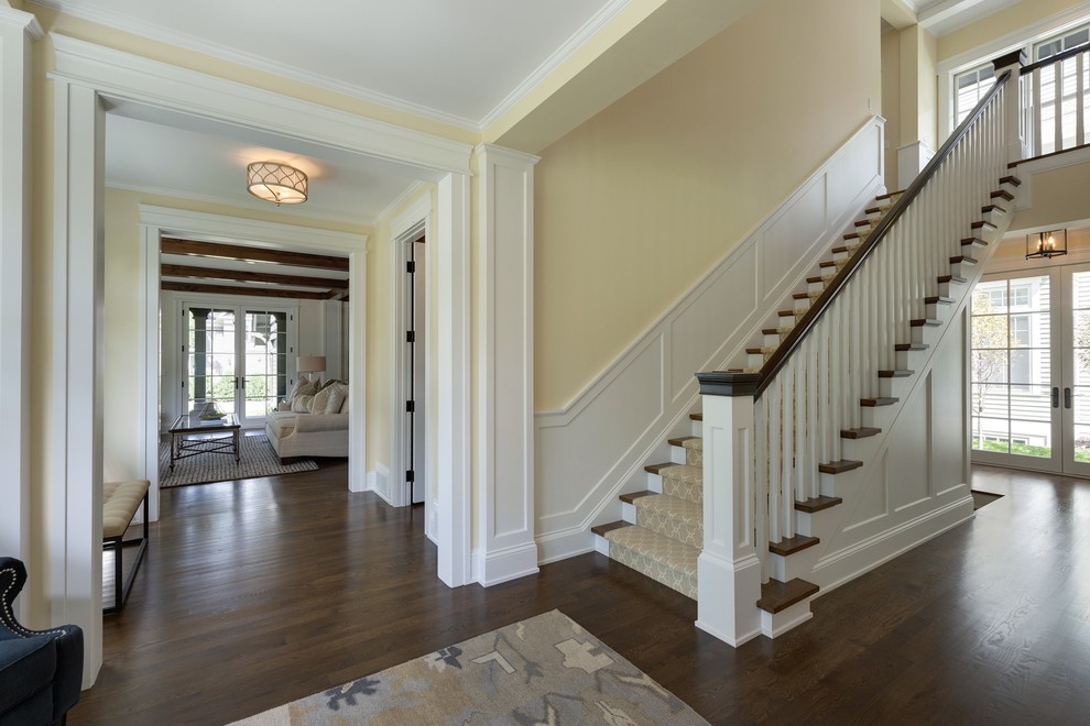 Photo of a mid-sized traditional foyer in Minneapolis with yellow walls, dark hardwood floors, a single front door and a white front door.