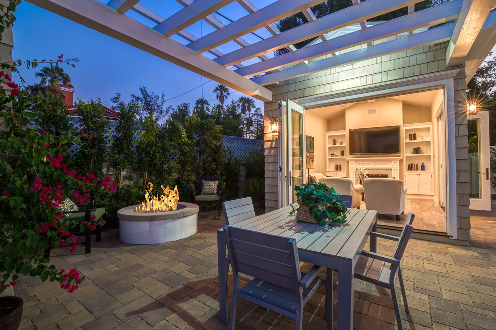 Small traditional backyard patio in Los Angeles with brick pavers, a fire feature and a pergola.