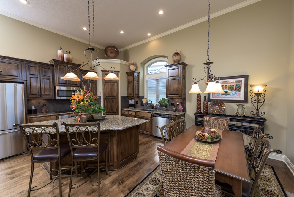 Inspiration for a traditional l-shaped eat-in kitchen in Kansas City with an undermount sink, raised-panel cabinets, dark wood cabinets, brown splashback, stainless steel appliances, medium hardwood floors and with island.