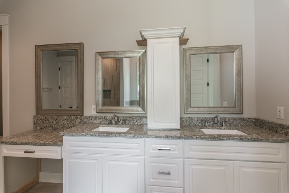 Design ideas for a large country master bathroom in Nashville with raised-panel cabinets, grey cabinets, a freestanding tub, an alcove shower, gray tile, porcelain tile, grey walls, porcelain floors, an undermount sink, granite benchtops, beige floor, a shower curtain and multi-coloured benchtops.