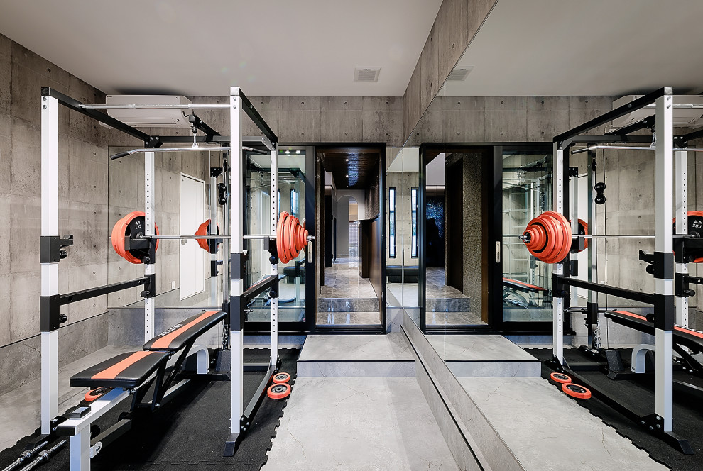 This is an example of an expansive contemporary home weight room in Kobe with grey walls, vinyl floors, grey floor and wallpaper.