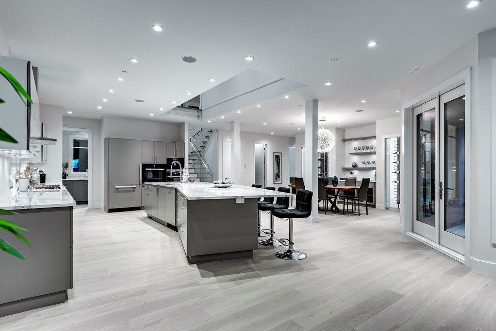 This is an example of a contemporary kitchen/dining combo in Vancouver with grey walls and light hardwood floors.