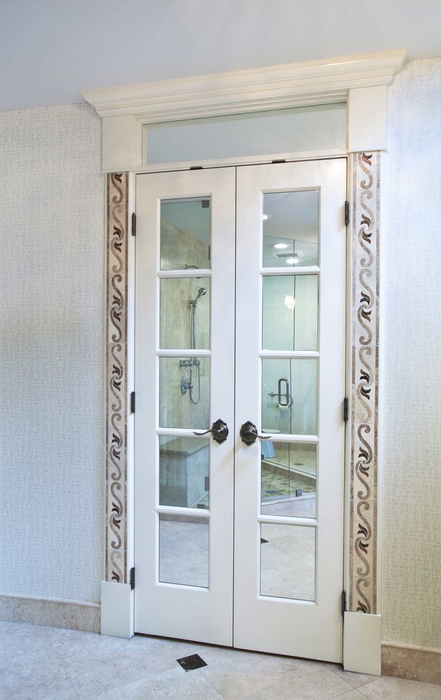 Design ideas for a mid-sized traditional gender-neutral walk-in wardrobe in Kansas City with recessed-panel cabinets, white cabinets and travertine floors.