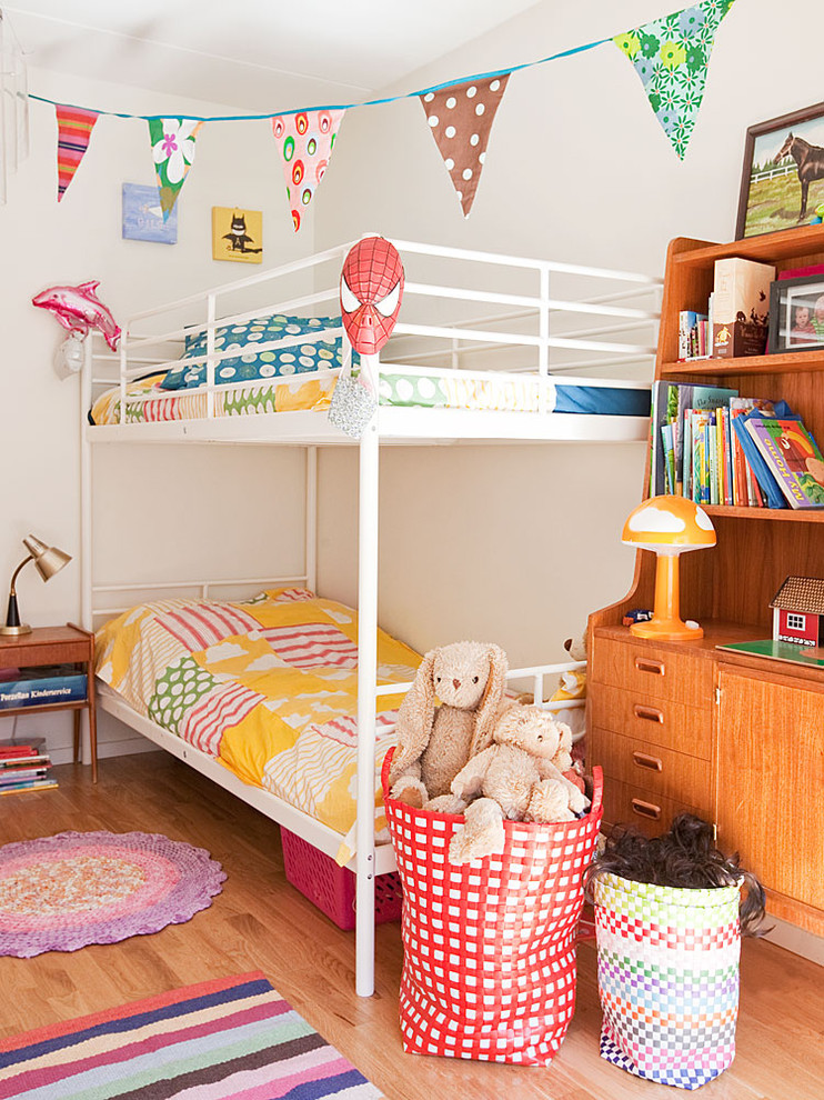 Inspiration för ett mellanstort minimalistiskt könsneutralt barnrum kombinerat med sovrum och för 4-10-åringar, med vita väggar och ljust trägolv