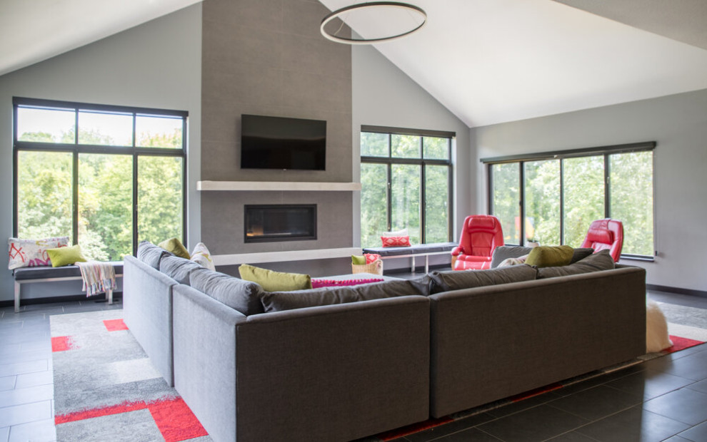 This is an example of a modern enclosed living room in Cedar Rapids with grey walls, a standard fireplace, a wall mounted tv, grey floors, a concrete fireplace surround, a coffered ceiling and slate flooring.