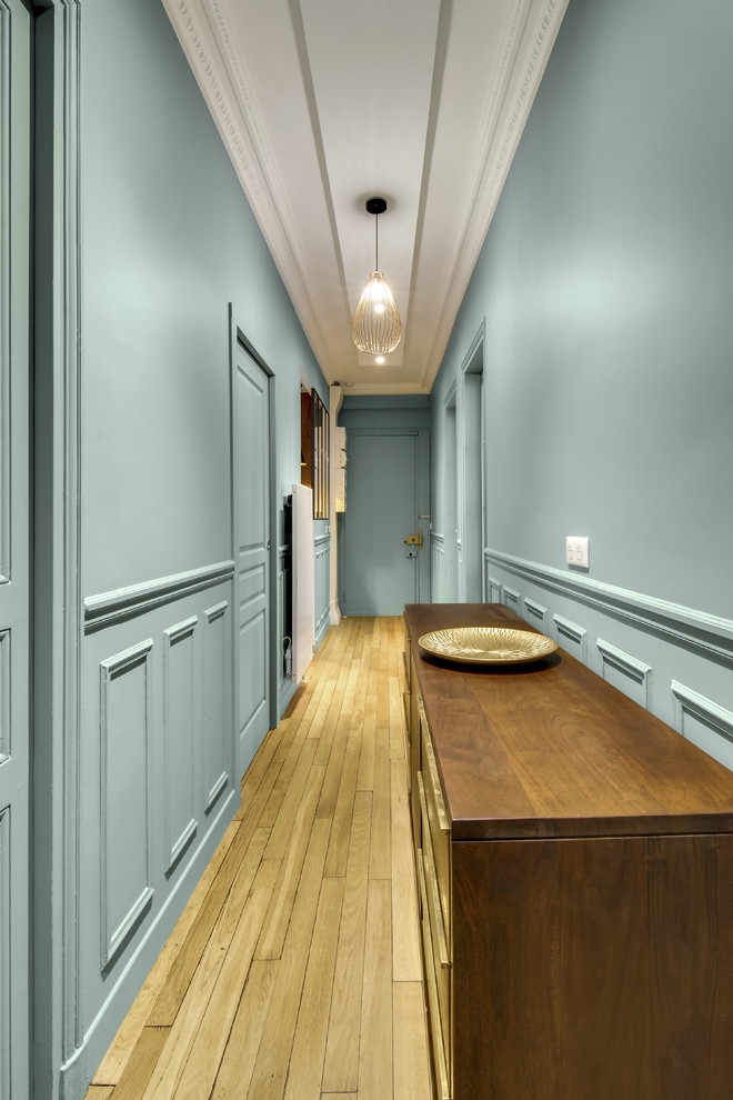 This is an example of an expansive contemporary hallway in Paris with blue walls, light hardwood floors and beige floor.