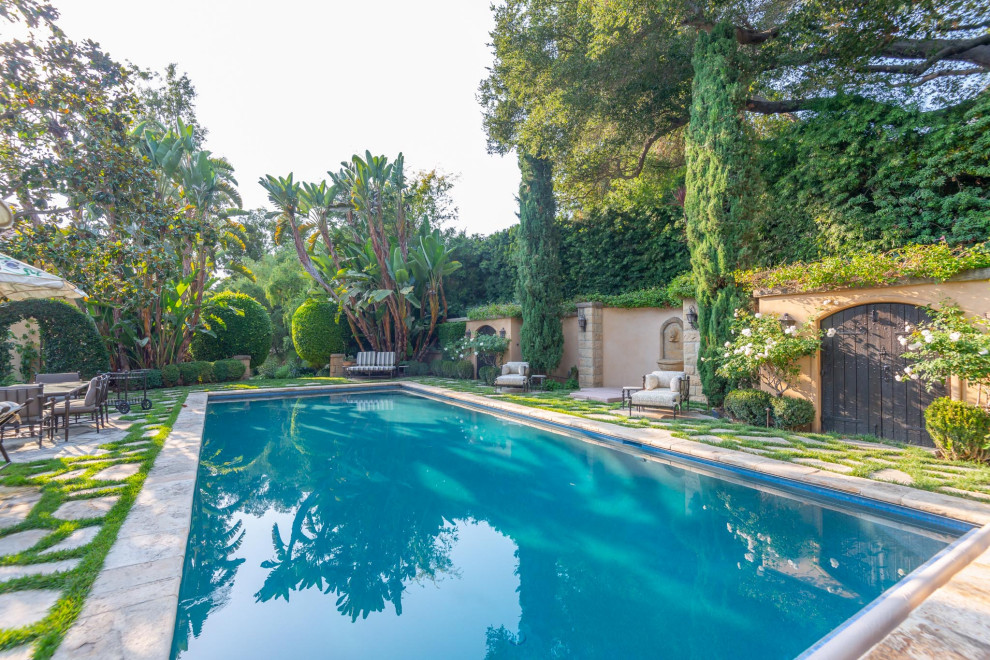 Inspiration pour un très grand piscine avec aménagement paysager arrière méditerranéen rectangle avec des pavés en pierre naturelle.