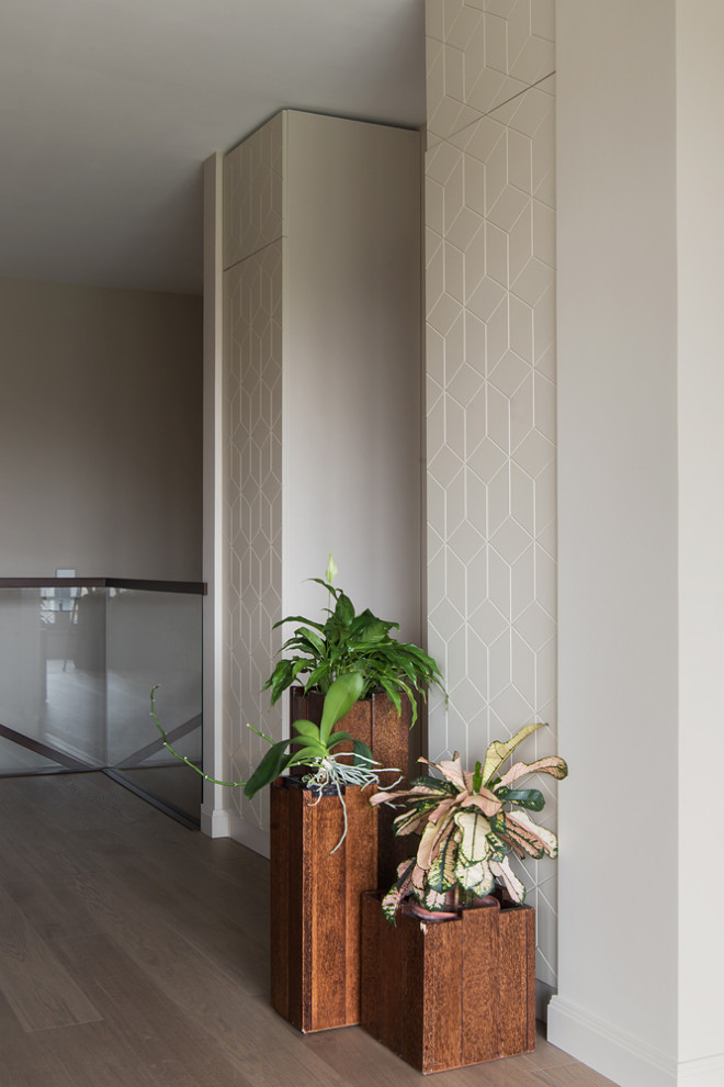 Ispirazione per un ingresso o corridoio minimal di medie dimensioni con pareti beige, pavimento in legno massello medio e pavimento beige