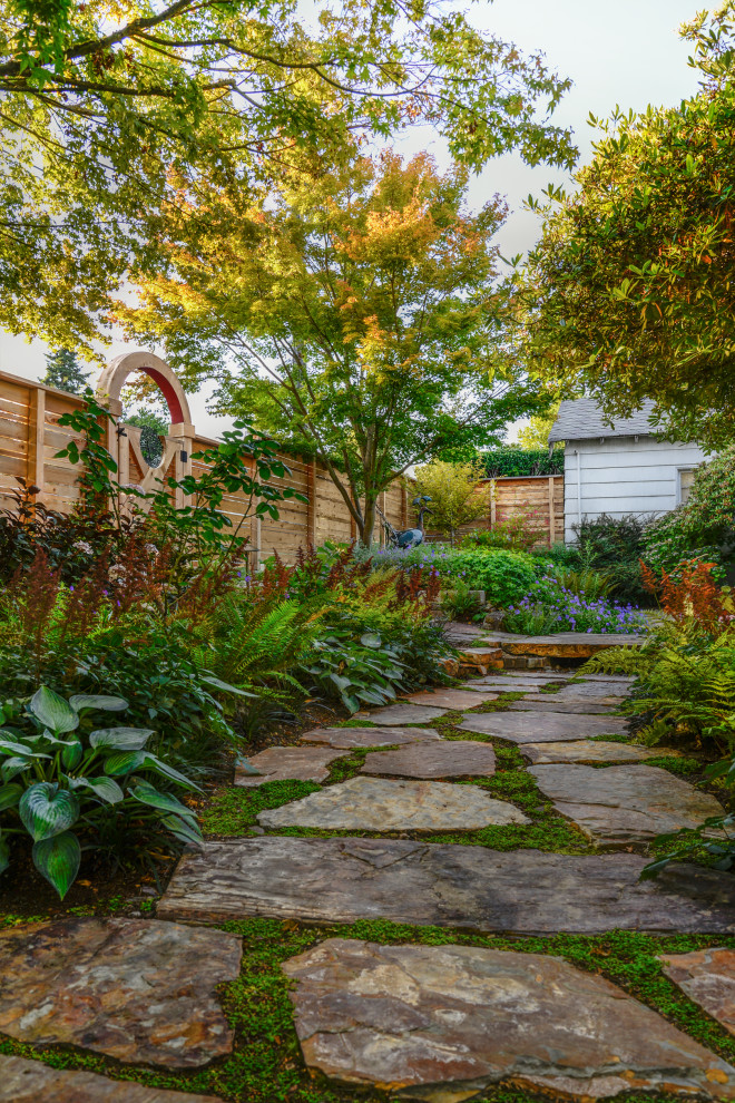 Photo of a mid-sized eclectic side yard partial sun garden in Seattle with with path and natural stone pavers.