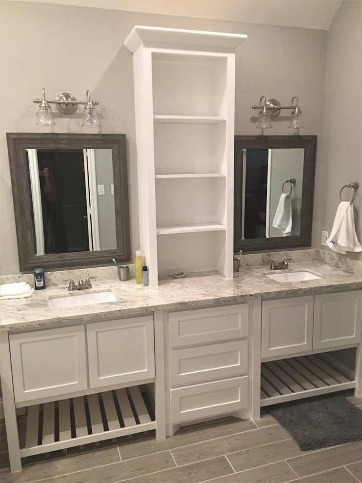 This is an example of a large transitional master bathroom in Houston with shaker cabinets, white cabinets, a double shower, white tile, ceramic tile, grey walls, porcelain floors, an undermount sink, granite benchtops, grey floor and an open shower.
