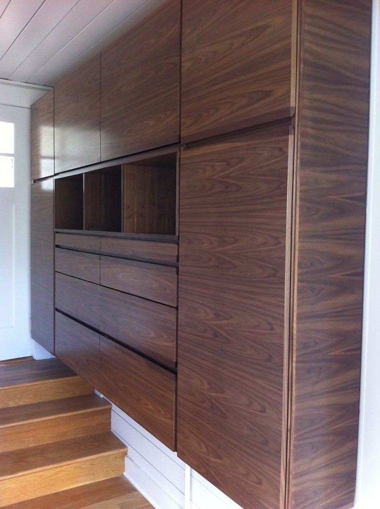Design ideas for a large midcentury men's dressing room in San Francisco with medium wood cabinets and light hardwood floors.