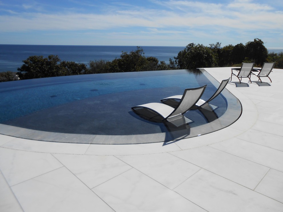 Large backyard stone and custom-shaped pool photo in New York