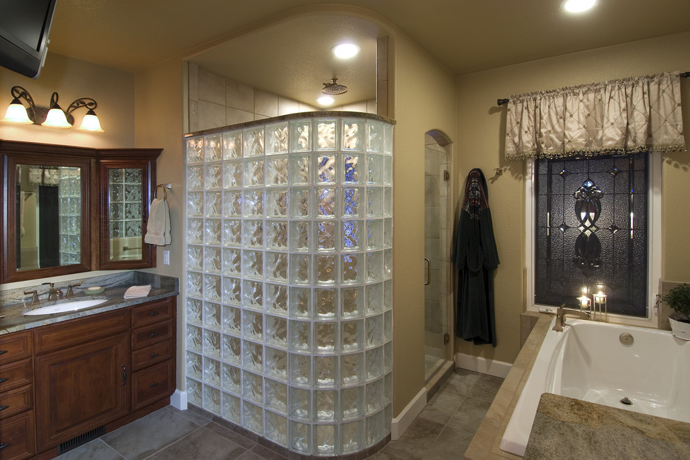 Photo of a mid-sized traditional master bathroom in Denver with medium wood cabinets, a drop-in tub, a corner shower, a two-piece toilet, multi-coloured tile, ceramic tile, beige walls, ceramic floors, an undermount sink and granite benchtops.